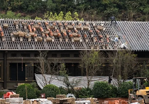 Roofing crew repairing tiled roof with scaffolding in Cape Town